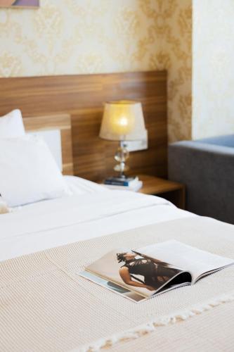 a book sitting on top of a bed with a lamp at TTR Vincent Hotel in Da Lat