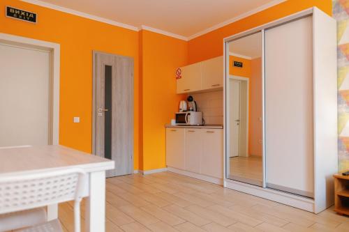 a kitchen with orange walls and a white table at BonApart in Lviv
