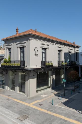 a white building on a street with a parking lot at Gagos Suites - Center in Larisa