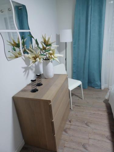 a room with a table with two vases with flowers on it at AL Boca da Canada in Água de Alto