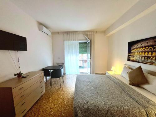 ein Schlafzimmer mit einem Bett und einem Tisch und einem Fenster in der Unterkunft Centro Metro Montitiburtini 510 in Rom