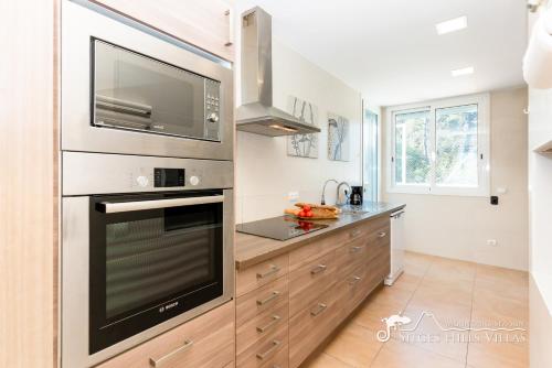 a kitchen with a large oven and a microwave at Villa Senita with Private Pool, close to Sitges in Olivella