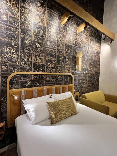 a bedroom with a bed with a black and white wallpaper at Hotel Du Cadran in Paris