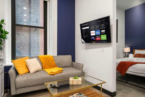 Una sala de estar con un sofá y un televisor. en CozySuites Stunning 1BR in Downtown Pitts #6, en Pittsburgh