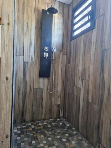 un bagno con doccia in una parete di legno di Leu Calyptus a Saint-Leu