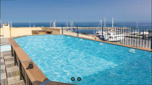 une grande piscine au sommet d'un immeuble dans l'établissement Appartement Solenzara direct sur le port, à Sari-Solenzara