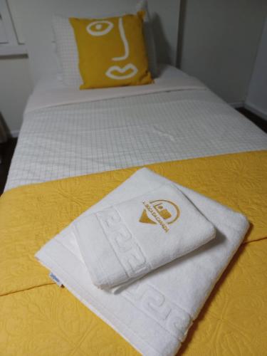 a pair of towels sitting on top of a bed at AL Boca da Canada in Água de Alto