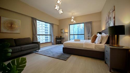 a large bedroom with a bed and a couch at Modern, spacious, Luxe 5BR plus Maid condo in JBR, near JBR Beach, Marina view, By La Buena Vida Holiday Homes in Dubai