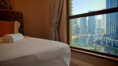 a bedroom with a window with a view of a city at Modern, spacious, Luxe 5BR plus Maid condo in JBR, near JBR Beach, Marina view, By La Buena Vida Holiday Homes in Dubai