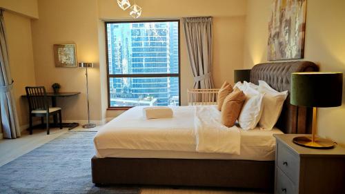 a bedroom with a large bed with a large window at Modern, spacious, Luxe 5BR plus Maid condo in JBR, near JBR Beach, Marina view, By La Buena Vida Holiday Homes in Dubai