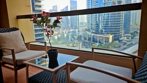 a balcony with a table and a vase with flowers on it at Modern, spacious, Luxe 5BR plus Maid condo in JBR, near JBR Beach, Marina view, By La Buena Vida Holiday Homes in Dubai