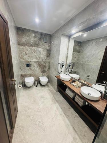a bathroom with two sinks and two toilets at Семеен хотел Анна-Кристина in Vidin