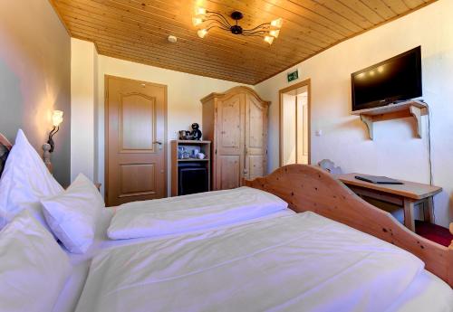 a bedroom with a large bed with a wooden ceiling at Pension Leithenwald in Zwiesel