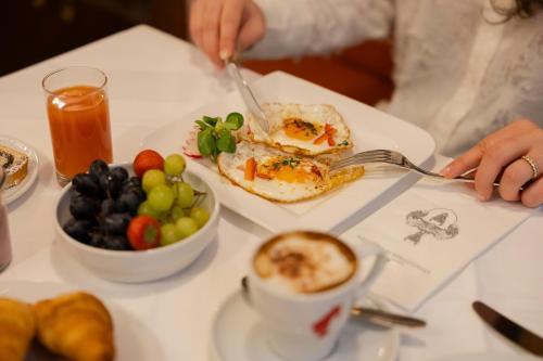 a table with a plate of food and a plate of fruit at Graben Hotel in Vienna