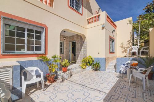 a house with a patio with chairs and plants at Casa do Sol - Estombar, Algarve in Estômbar