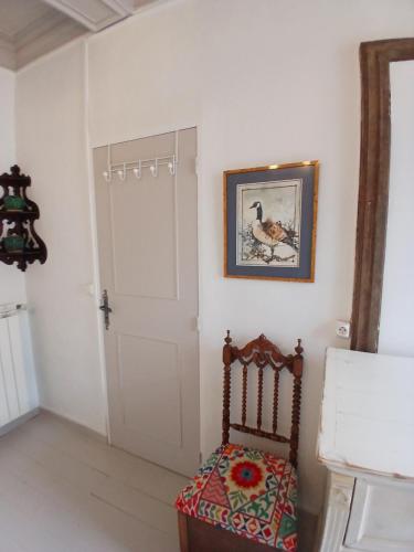 a room with a chair and a white door at Pierres anciennes et soirées douces Coeur de ville in Pézenas