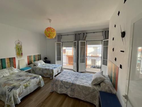 a bedroom with two beds and a large window at Casa rural VTAR con piscina in Rosal de la Frontera