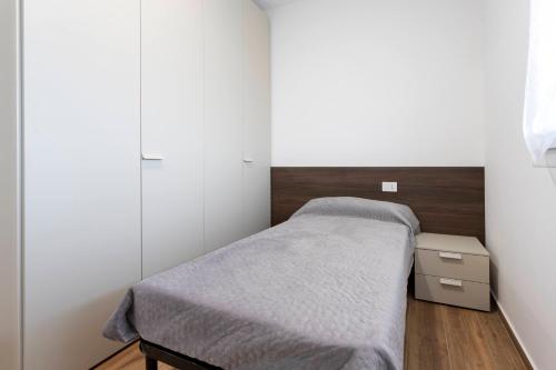 a small bedroom with a bed and a dresser at Romana Luxury Suite - SELF CHECK-IN WI-FI in Oleggio