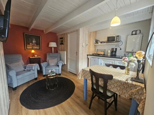 a living room with a table and a kitchen at Omas kleine huisje in Veere