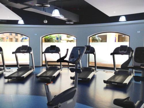 a gym with several treadmills in a room with windows at Modern, spacious, Luxe 5BR plus Maid condo in JBR, near JBR Beach, Marina view, By La Buena Vida Holiday Homes in Dubai