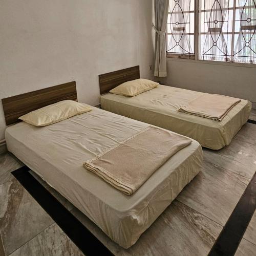two beds sitting next to each other in a bedroom at Pinus Homestay by DT Guesthouse in Bantarkamang