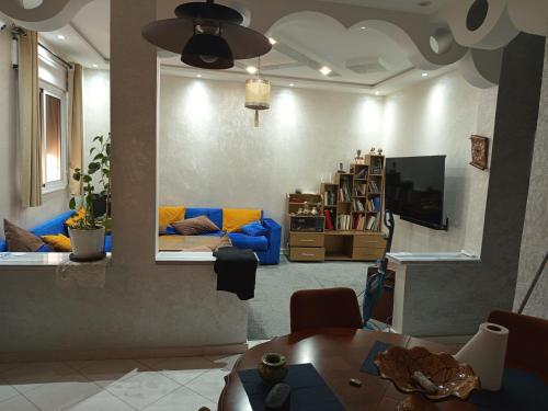 a living room with a couch and a tv at À mi-chemin in Larache