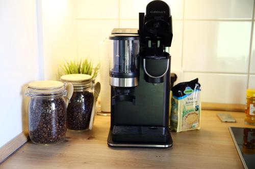 a coffee maker sitting on a counter next to jars at Ferienapartment Saarbrücken Zentrumsnah mit Luxus-Heimkino, Grill, Balkon & Miele Küche in Saarbrücken