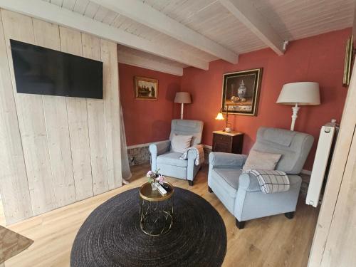 a living room with two chairs and a table at Omas kleine huisje in Veere