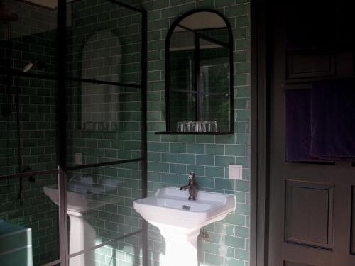 a bathroom with a sink and a mirror at Stay Classy - Tiny House in Otterlo