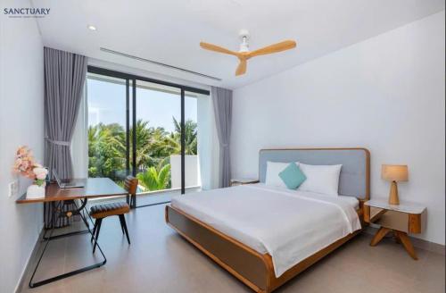 a bedroom with a bed and a desk and a window at Villa Hồ Tràm 4 Phòng Hồ bơi riêng cao cấp - Sanctuary Resort in Ho Tram