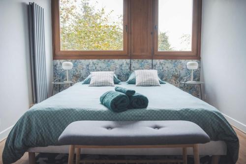 une chambre avec un grand lit avec deux fenêtres dans l'établissement Grand appartement rénové, tout confort, à Nancy