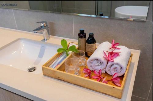 a tray with towels and glasses on a bathroom sink at Villa Hồ Tràm 4 Phòng Hồ bơi riêng cao cấp - Sanctuary Resort in Ho Tram