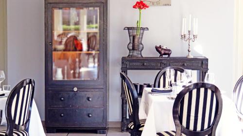 a dining room with a table with chairs and a cabinet at Hotel mon Soleil in La Gaude