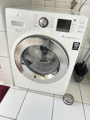 a washing machine sitting in a kitchen at Ferienapartment Saarbrücken Zentrumsnah mit Luxus-Heimkino, Grill, Balkon & Miele Küche in Saarbrücken