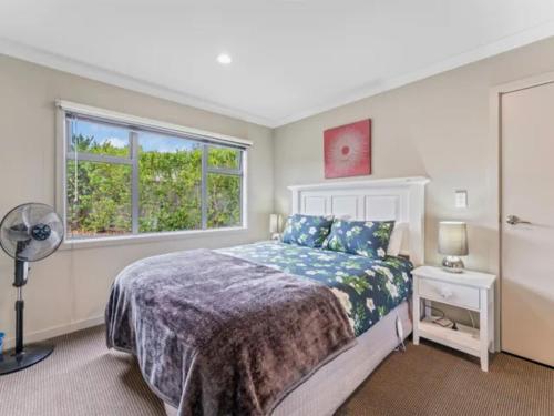 ein Schlafzimmer mit einem Bett und einem Fenster in der Unterkunft Noble Retreat - Taupō Holiday House in Taupo