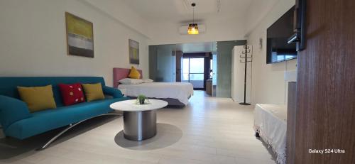 a living room with a couch and a bed and a table at 楓葉閣溫泉會館Hot Spring Hotel in Hsin-hsing