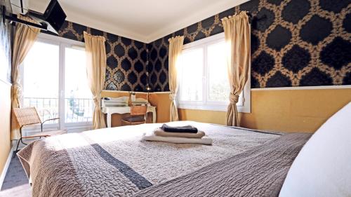 a bedroom with a bed with towels on it at Hotel mon Soleil in La Gaude