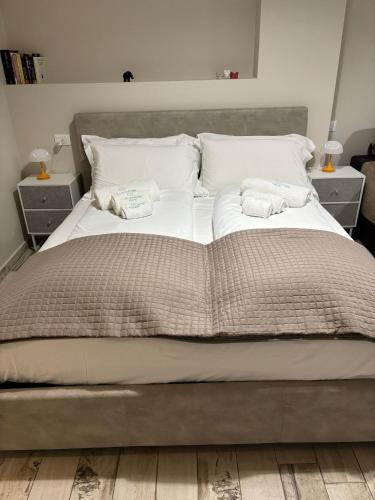 een groot bed met witte lakens en kussens erop bij Appartamento con patio in Monopoli