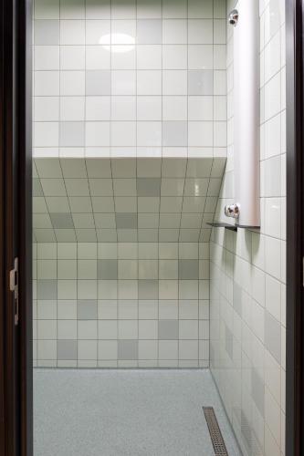 a bathroom with white tiled walls and a shower at CoolDocks in Rotterdam