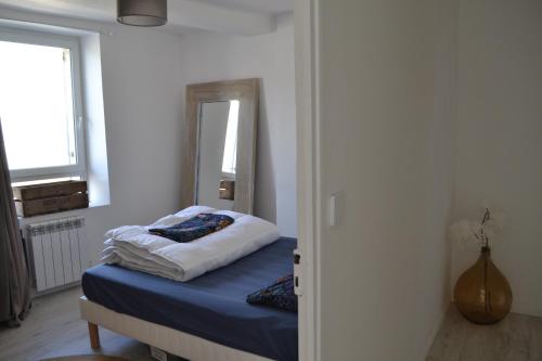 une petite chambre avec un lit et un miroir dans l'établissement La Belle Escale, à Ver-sur-Mer