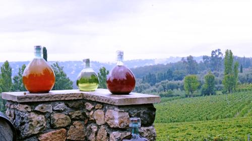 three wine bottles sitting on top of a stone wall at Hotel mon Soleil in La Gaude
