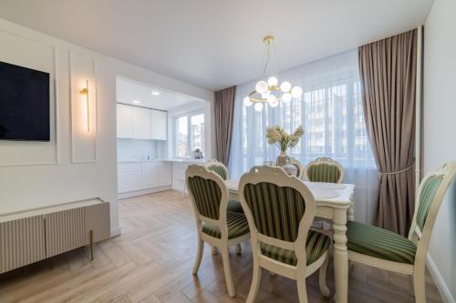 een keuken en eetkamer met een tafel en stoelen bij Frida Luxury Apartments in Šiauliai