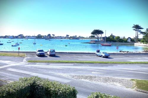 une rue avec des voitures garées dans un parking à côté d'un lac dans l'établissement La Corniche-Maison vue mer avec grand jardin, à Brignogan-Plage