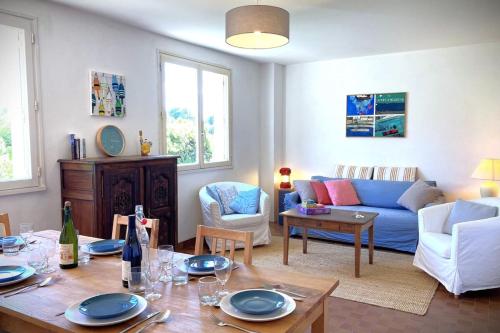 un salon avec un canapé bleu et une table dans l'établissement La Corniche-Maison vue mer avec grand jardin, à Brignogan-Plage