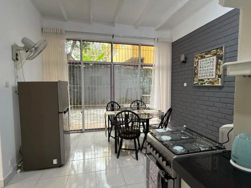 a kitchen and dining room with a table and a refrigerator at Dwellio -Ratmalana - Greater Colombo in Ratmalana