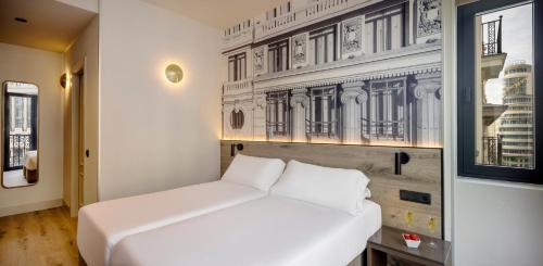 Una cama blanca en una habitación con una pared. en Regente Hotel, en Madrid