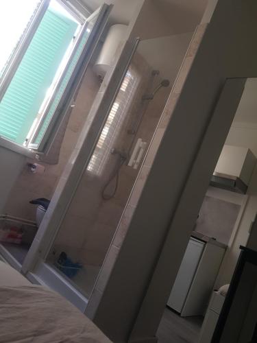 une salle de bain avec une douche avec une porte vitrée dans l'établissement Chambre Meublée, à Marseille