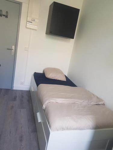 Cette petite chambre comprend un lit et une télévision à écran plat. dans l'établissement Chambre Meublée, à Marseille