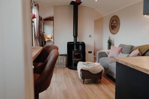 a living room with a couch and a wood stove at Brackenslack Shepherds Huts in Maulds Meaburn