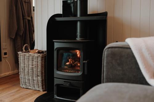 a black stove with a fire in a room at Brackenslack Shepherds Huts in Maulds Meaburn